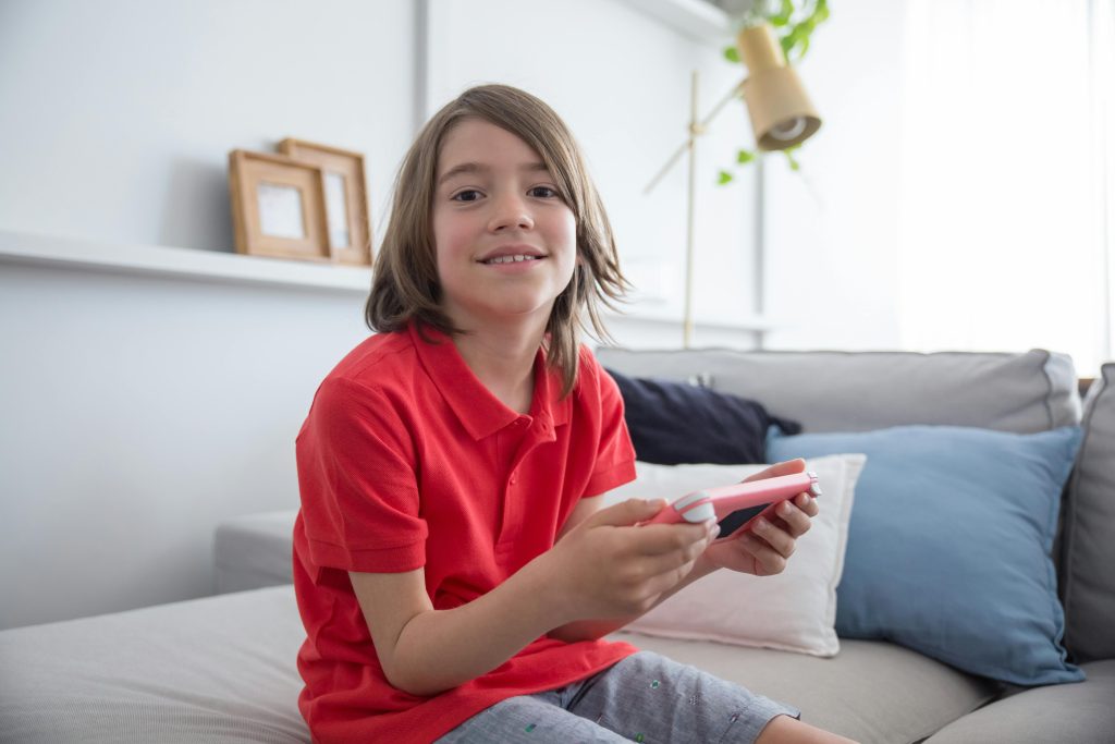 Boy Wearing Red Shirt Sitting on the Sofa